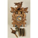 A mid Century carousel cuckoo clock, musical with traditional pine cone styled weights and leaf