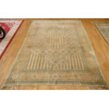 A signed Persian rug, the pale gold and green geometric pattern field with outer border....
