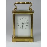 A large brass carriage clock, white enamel dial with Roman numerals, 15cm