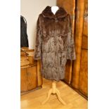 A ladies mid length brown and a full length silver fur coats