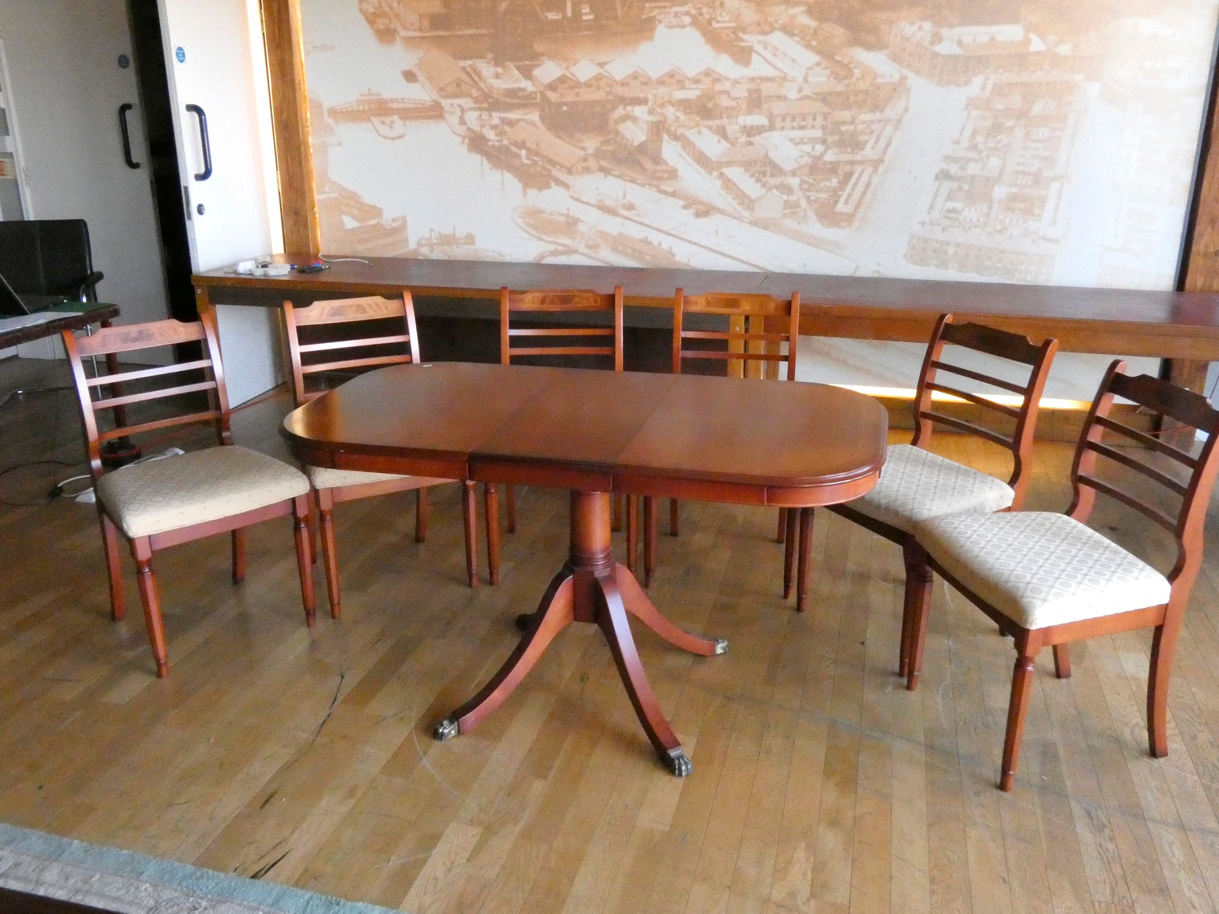 An extending oval dining table (built in leaf) together with a set of six matching dining chairs.