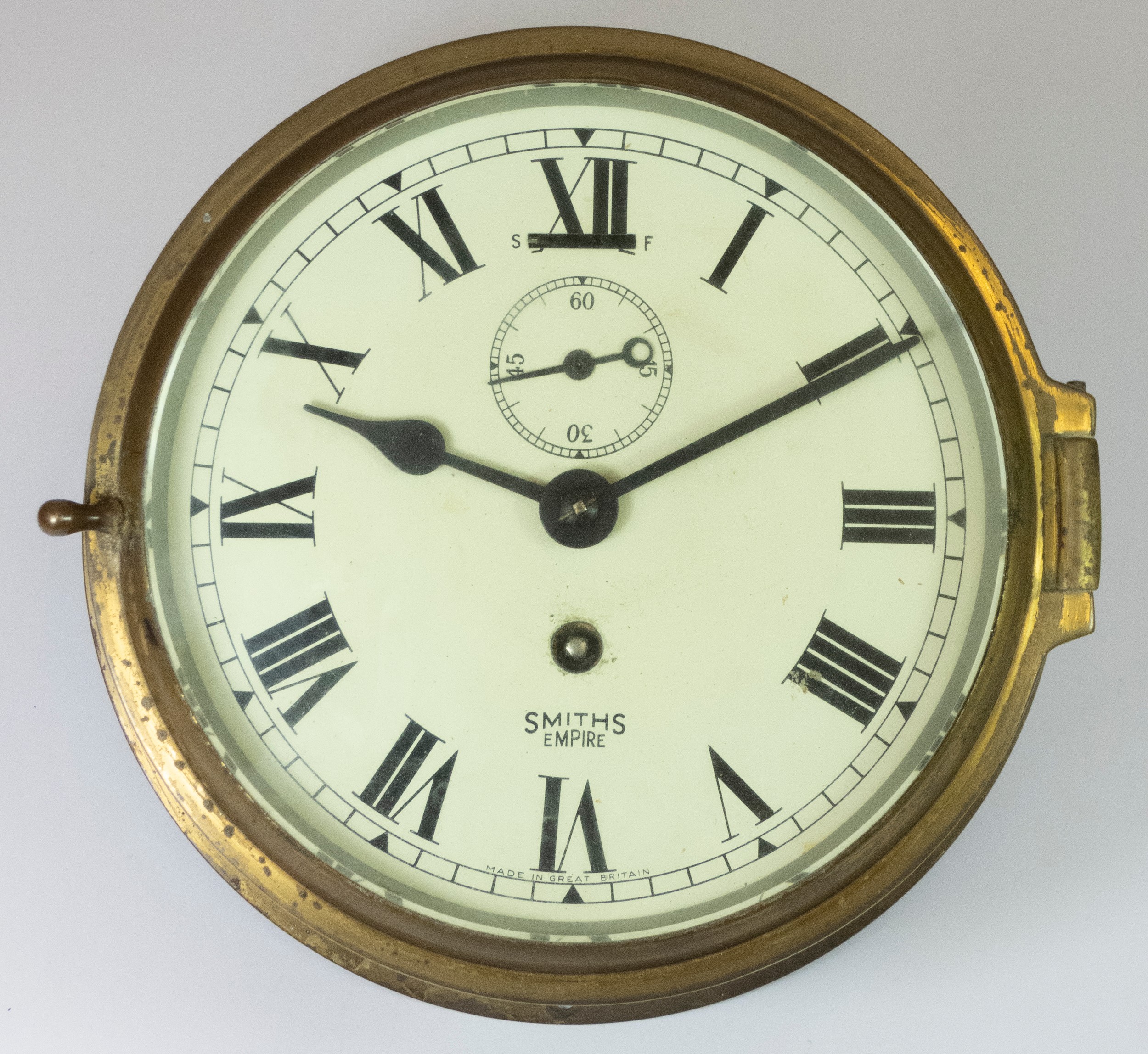 A Smiths Empire brass bulkhead clock, the 6inch dial, with subsidiary seconds dial, Roman
