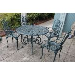 A cast metal garden dining set, painted dark green with floral decoration, with four