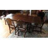 A Jacobean style oak draw leaf dining table raised on turned uprights supported by carved