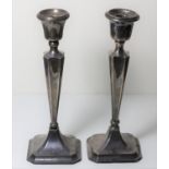 A pair of silver candlesticks, Chester 1922, drilled for electricity, one A/F, loaded, 27cm.