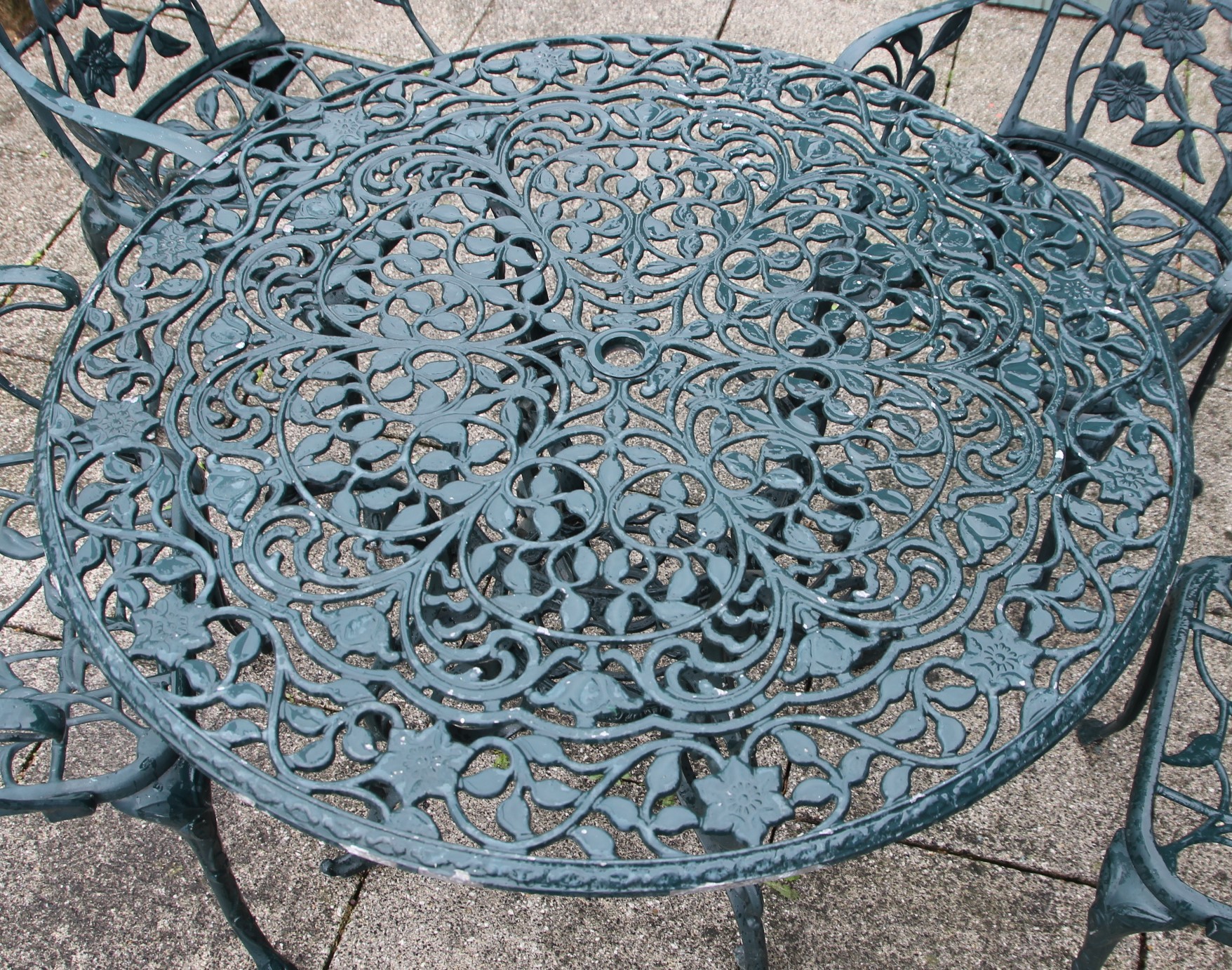 A cast metal garden dining set, painted dark green with floral decoration, with four - Image 4 of 4