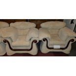 A three piece suite comprising of a three seater sofa and two armchairs, upholstered in a cream
