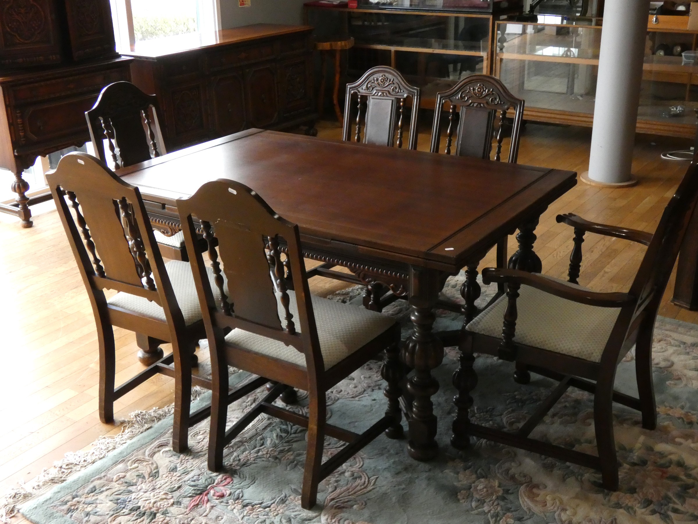 A Jacobean style oak draw leaf dining table raised on turned uprights supported by carved - Image 4 of 10