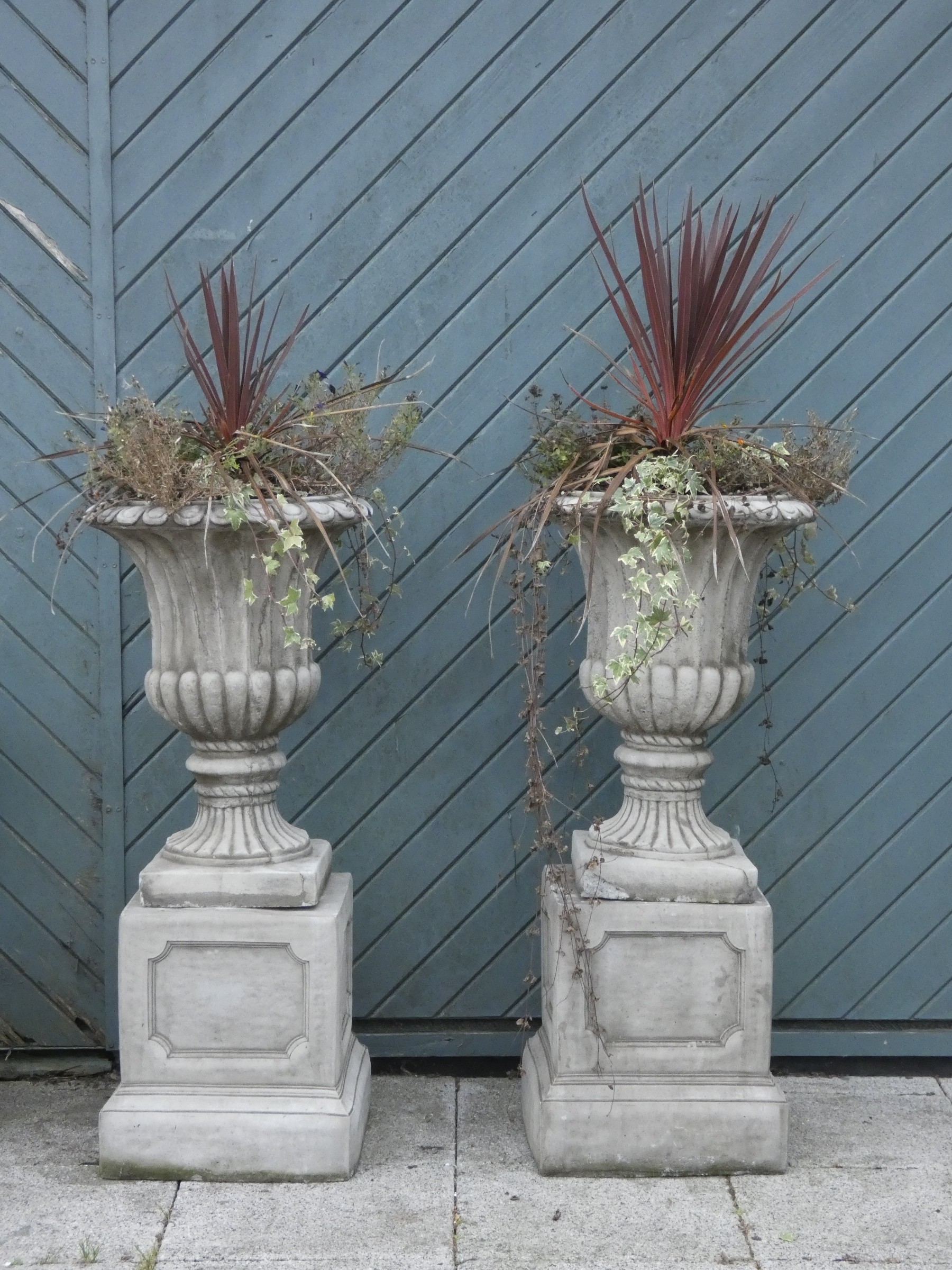 A pair of garden urns on column bases, cast in limestone, height, 115cm (2) These are very heavy