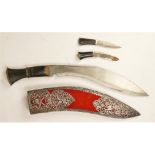 A ceremonial kukri, with two small knives, the scabbard with pierced white metal decoration,