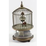 A novelty bird in a cage clock, one bird seated on a ball for the seconds, the other the tick