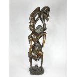 A Makonde Ujamaa blackwood sculpture, depicting human figures climbing up and holding onto each
