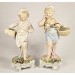 A Continental pair of boy and girl statues, unmarked, late 19th/early 20th century, both carrying