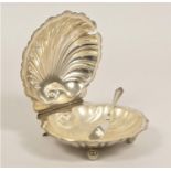 A silver oyster shell lidded butter dish, Birmingham 1927, with silver butter knife and plastic