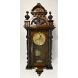 A Vienna style wall clock, carved mahogany case with brass enamelled dial, pendulum & weights.