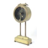 A 1920s gravity powered desk clock, by Kee-Less Clock Company, glass dial in brass case,