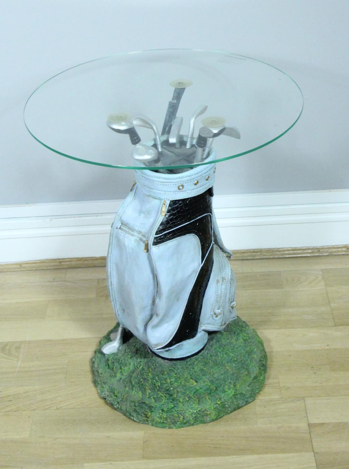 A novelty resin golfing side table in the form of a bag of clubs with, circular tuffin glass top,