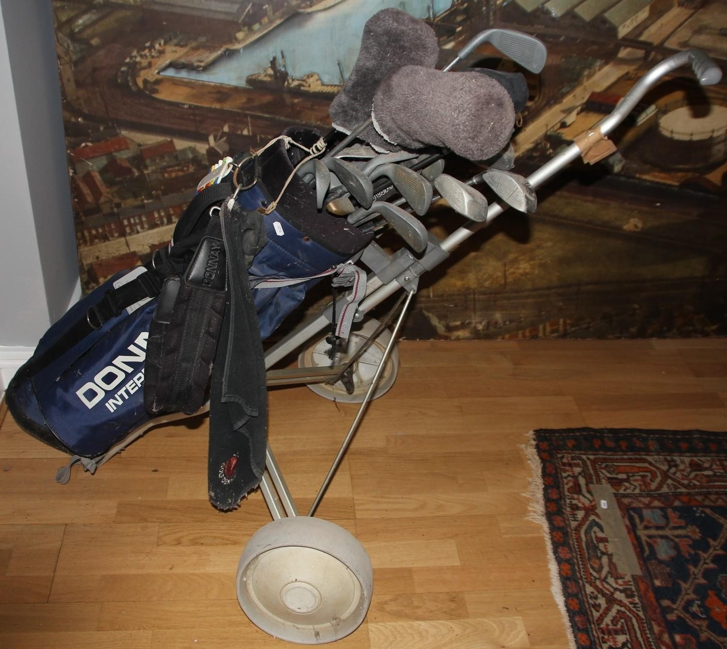 A selection of golf clubs/irons, makers to include Wilson, Gallery and Donnay, compete with golf bag