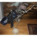 A selection of golf clubs/irons, makers to include Wilson, Gallery and Donnay, compete with golf bag