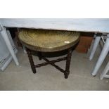 An Indian brass table on folding barley twist wood frame, diameter approx. 60cm