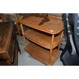 A light stained Ercol tea trolley on shepherds casters, badly marked to top