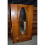 An early 20th Century oak mirror door wardrobe, no base or top plinth