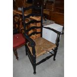 A traditional rush seated ladder back carver chair