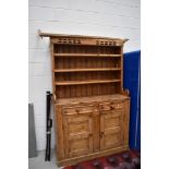 A rustic kitchen dresser, double cupboard and drawer base with plate rack back, approx. width 127cm