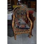 A wickerwork armchair and Art Nouveau style cushions