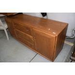 A mid stain Ercol sideboard, having central drawer section flanked by cupboards, width approx.
