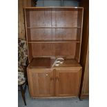 A light Ercol dresser of small proportions having plate rack back over double cupboard, on shepherds