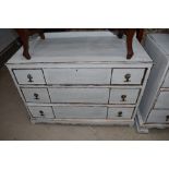 A 'shabby chic' chest of three drawers having ledge back Width approx. 99 cm