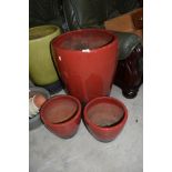 Three red glazed planters, largest being a height of 60cm