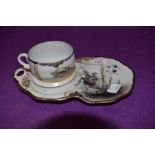 A Chinese eggshell tennis set or tea cup and saucer decorated with stalks and river scene
