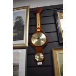 A traditional wooden wall mounted barometer.