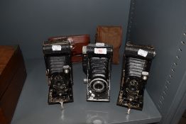 Three extending photography cameras including Eastman Kodak and Foldex 20