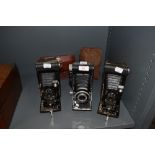 Three extending photography cameras including Eastman Kodak and Foldex 20