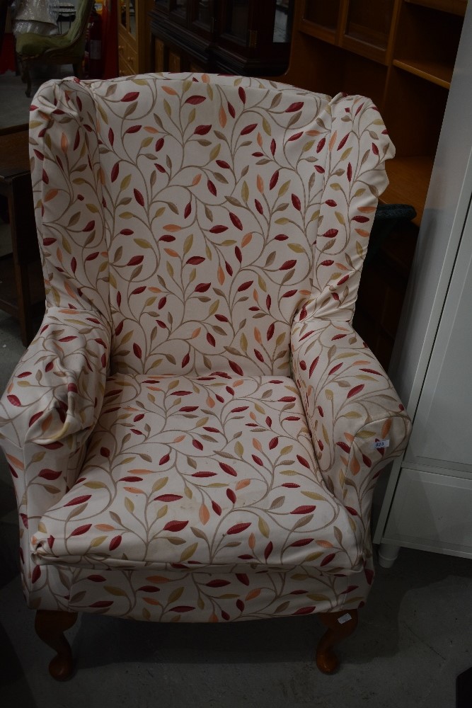 A traditional wing back armchair, with loose cover