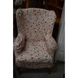 A traditional wing back armchair, with loose cover