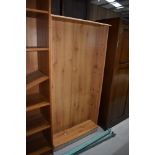 A pine effect laminate bookshelf, approx. width 75cm, height 150cm