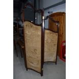A Victorian mahogany trifold modesty screen having glazed upper panels and damask style lined lower,