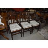 A set of six (four plus two) oak rail back dining chairs with later upholstered seats