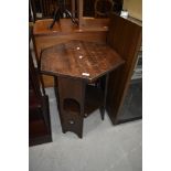 An Arts and Crafts style dark oak occasional hexagonal table, having arch and heart motifs to