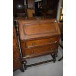 An early 20th Century oak bureau of cushion design, width approx. 73cm