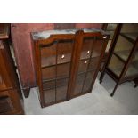An early 20th Century glazed front oak bookcase bureau top