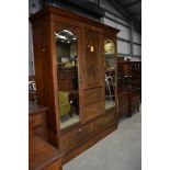 An Edwardian mahogany and inlaid bedroom suite comprising mirror door wardrobe with central press