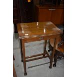 An Arts and Crafts golden oak fold over card table, having squashed heart design to frieze