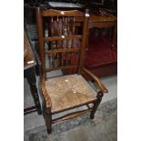 A traditional elm Lancashire style spindle back armchair having rush seat