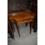 An Edwardian mahogany and inlaid fold over card table of shaped form on square tapered legs, width