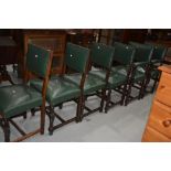 A set of six (four plus two) oak and green studded leather chairs, in the municipal style